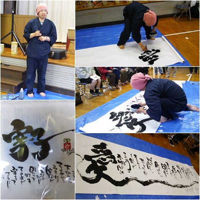 会場内に設置された大きな紙にインスピレーションで詩を書いているごとうみのるさん